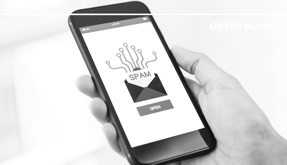 mão segurando celular preto com uma imagem de spam na tela