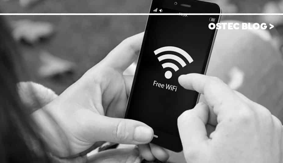 Mãos segurando celular que exibe logo o sinal de Wi-Fi em sua tela.